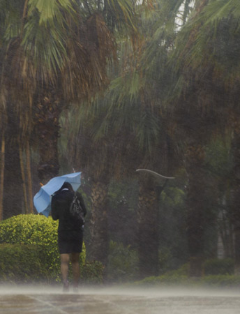 A women walks against heavy wind and rains in Xiamen, East China's Fujian province on Oct 23, 2010.