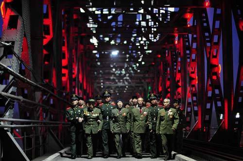 Veteran Chinese People's Volunteers (CPV) soldiers from central China's Henan Province walk across a bridge in an event to mark the 60th anniversary of the entry of CPV into the Korean War front in Dandong, northeast China's Liaoning Province, Oct 22, 2010. [Photo/Xinhua]