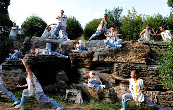 Students from martial arts schools practice Wushu at the Songshan Mountain Shaolin Temple scenic spot in Dengfeng city of Central China's Henan province, Oct 23, 2010. More than 60,000 Wushu students performed Chinese kungfu along the 10-kilometer road leading to the Shaolin Temple to welcome the guests from 56 countries and regions for the Eighth International Shaolin Martial Arts Festival, which began on Friday night. [Photo/Xinhua] 