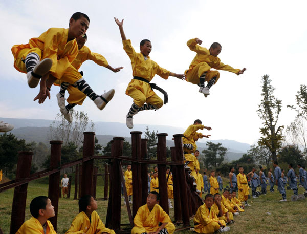 Students from martial arts schools practice Wushu at the Shaolin Temple scenic spot in Dengfeng city of Central China's Henan province, Oct 23, 2010. [Photo/Xinhua] 