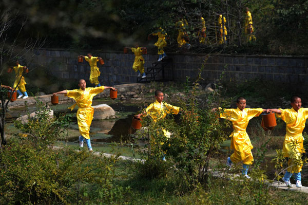 Students from martial arts schools practice Wushu at the Shaolin Temple scenic spot in Dengfeng city of Central China's Henan province, Oct 23, 2010. [Photo/Xinhua] 