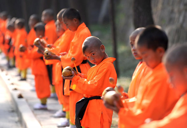 Students from martial arts schools welcome guests at the Shaolin Temple scenic spot in Dengfeng city of Central China's Henan province, Oct 23, 2010. [Photo/Xinhua]
