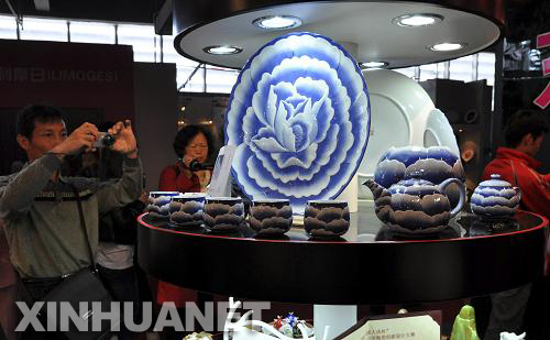 Visitors take pictures of ceramic crafts during the China Jingdezhen International Ceramic Fair on October 19, 2010.