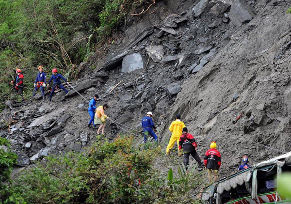 Rescuers search for missing mainland tourists who were trapped on Taiwan's Highway No. 9, which connects Suao, Ilan County, and Hualien, Hualien County, after it was damaged by the landslides caused by Typhoon Megi, northern Taiwan October 23, 2010. [Xinhua photo]