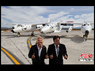 Virgin boss Richard Branson (L) and New Mexico Governor Bill Richardson (R) pose with the Virgin Galactic VSS Enterprise spacecraft after it's first public landing during the Spaceport America runway dedication ceremony. [Chinanews.com]