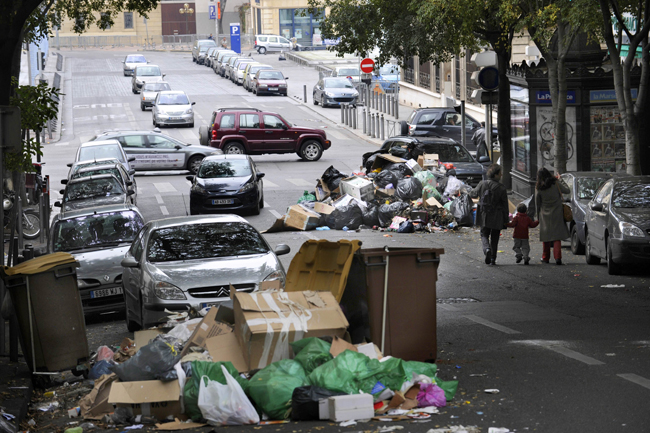 A child rides his scooter in front garbage piled on October 24, 2010 in a street of Marseille, as a result of a strike by rubish collectors since October 12 to protest against French President&apos;s bid to raise the retirement age. The pensions reform bill was approved by the Senate on October 22, and the text will be reconciled October 25 with the draft passed earlier by the lower house. However, strikes have continued across the industry. [Xinhua] 