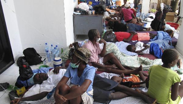 Patients suffering from diarrhea and other cholera symptoms are helped by other residents as they wait for treatment at the St. Nicholas hospital in Saint Marc, Haiti, Friday, Oct. 22, 2010. [Xinhua]