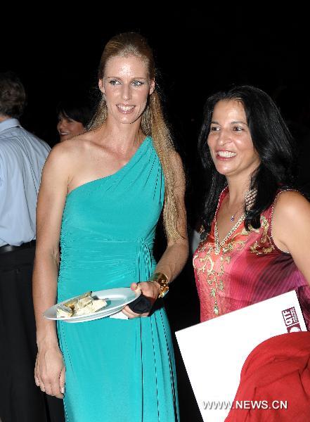 Elena Dementieva (L) of Russia poses for a photograph with her fan after the draw for the WTA Tour Championships in Doha, capital of Qatar, Oct. 24, 2010. The tournament will take place in Doha from Oct. 26 to Oct. 31. (Xinhua/Chen Shaojin)