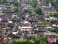 Lijiang is an old city in beautiful surroundings in northwest Yunnan. It is situated on a plateau at an elevation of 2,600 meters and is impressive due to its scenery and lush vegetation. People go there for its tranquil atmosphere, classical buildings, delicate snacks and the unique customs of Naxi People. It is a real delight in autumn, visitors will find that the temperature changes greatly in a day. It is wise to bring warm clothes as well as sun protection and an umbrella. [Photo by Niu Le] 