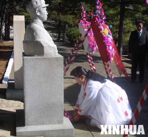 A girl places flowers to the tomb of Mao Anying, son of former Chinese leader Mao Zedong, on October 23, 2010. A series of ceremonies are held in China and the Democratic People’s Republic of Korea to mark the 60th anniversary of the entry of the Chinese People's Volunteers (CPV) into the Korean War front. 