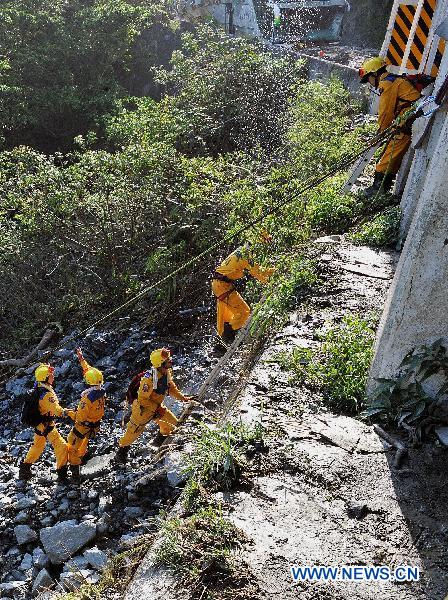 Rescuers search for missing people near the landslide-hit Suhua Highway in Taiwan, southeast China, Oct. 24, 2010. The rain-triggered landslides have left 11 people dead and 26 others missing, including 20 tourists from the Chinese mainland.