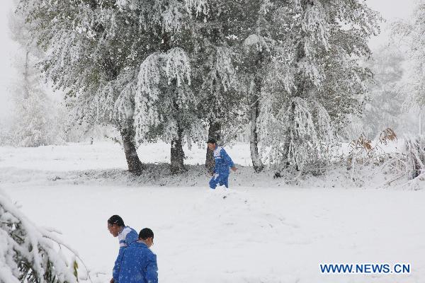 Children play in the snow-covered field in the Ganzhou District of Zhangye, a city in northwest China&apos;s Gansu Province, Oct. 24, 2010.