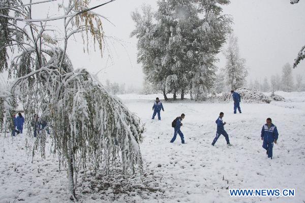 Children play in the snow-covered field in the Ganzhou District of Zhangye, a city in northwest China&apos;s Gansu Province, Oct. 24, 2010.