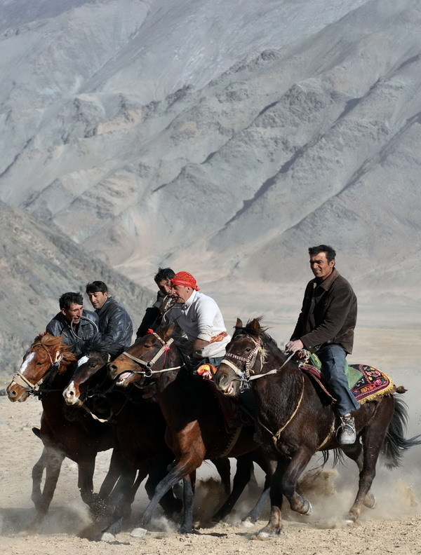 Herdsmen of the Tajik ethnic group scramble to recover the body of a goat during a competition 4,000 meters above sea level in Tashi Kuergan Tajik autonomous county, the Xinjiang Uygur autonomous region, Oct 24. The Tajik people in the Pamir Plateau usually choose to hold wedding ceremonies in the harvest season of autumn, and the goat scrambling competition is an important part of the wedding celebrations. [Xinhua] 