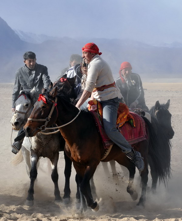 Herdsmen of the Tajik ethnic group scramble to recover the body of a goat during a competition 4,000 meters above sea level in Tashi Kuergan Tajik autonomous county, the Xinjiang Uygur autonomous region, Oct 24. The Tajik people in the Pamir Plateau usually choose to hold wedding ceremonies in the harvest season of autumn, and the goat scrambling competition is an important part of the wedding celebrations. [Xinhua] 