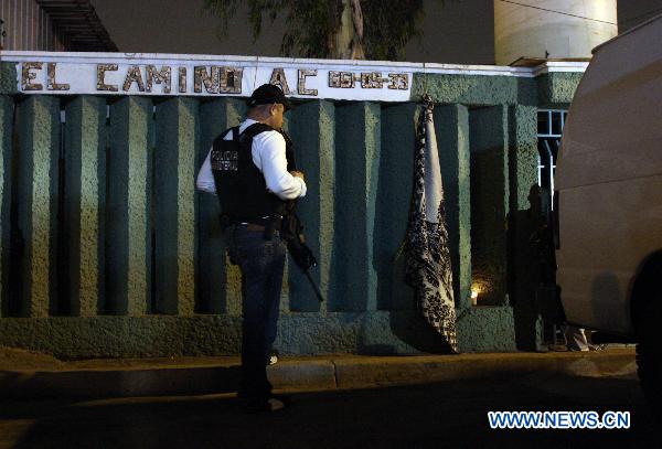 A police officer stands guard outside the rehabilitation center &apos;El Camino&apos; in Tijuana, Mexico, Oct. 25, 2010. A gang of armed men shot and killed 13 recuperating drug addicts on Sunday at a rehabilitation center in Tijuana. [Xinhua]