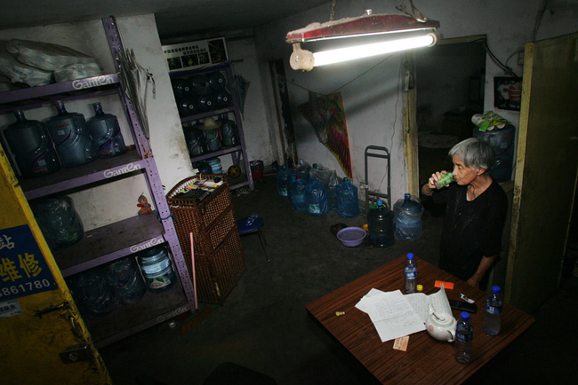 Gao Meiyun, 70, drink water after delivering water at Yang village of Shijingshan district on July 29, 2010 in Beijing, China. Gao, weight 37.5kg, for supporting her disabled son and retarded grandson has to deliver 40 - 60 containers water which per one weight 20kg every day. [sohu.com]