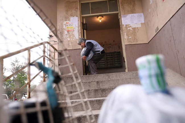 Gao Meiyun, 70, carries water at Yang village of Shijingshan district on Ocotber 19, 2010 in Beijing, China. Gao, weight 37.5kg, for supporting her disabled son and retarded grandson has to deliver 40 - 60 containers water which per one weight 20kg every day. [sohu.com]