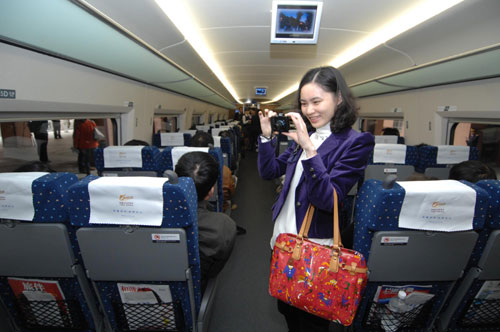 A passenger takes a photo of her friend on a train on Shanghai-Hangzhou high-speed railway, Oct 25, 2010. [Xinhua]