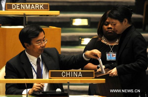 Wang Min (L), China's deputy permanent representative to the United Nations, votes at the General Assembly hall at the UN Heaquarters in New York, Oct. 25, 2010. China on Monday was re-elected to the UN Economic and Social Council (ECOSOC), one of the six principal UN organs tasked to coordinate the economic, social and related work of the United Nations and its specialized agencies and institutions -- known as the United Nations family organizations. [Shen Hong/Xinhua]