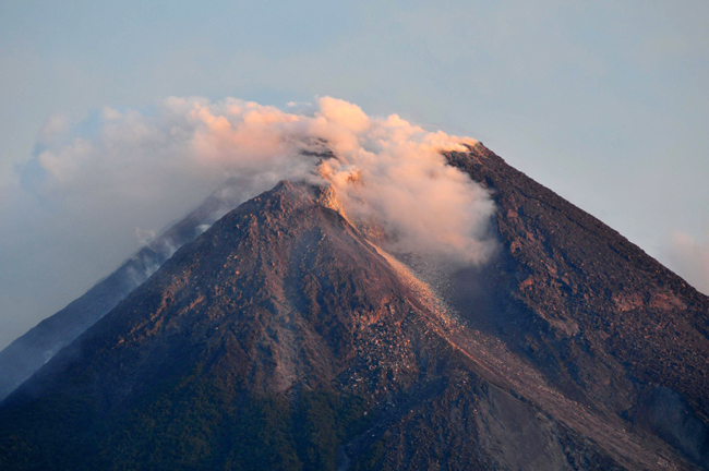 A view of the Mount Merapi volcano emitting smoke is seen from Cangkringan village in the district of Sleman, central Java Oct 25, 2010. Indonesia Volcanology and Geological Disaster Mitigation Center issued a high alert status warning for the volcano, according to local radio Elsinta. [Xinhua] 