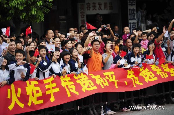 Local residents cheer for the torch relay for the 16th Asian Games in Heyuan City, south China's Guangdong Province, Oct. 25, 2010. (Xinhua/Liang Xu) 