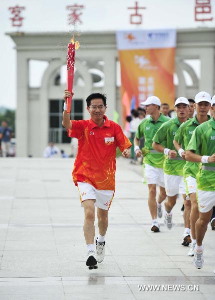 Torchbearer Wu Youbi, the vice mayor of Heyuan City runs during the torch relay for the 16th Asian Games in Heyuan City, south China's Guangdong Province, Oct. 25, 2010. (Xinhua/Liang Xu)