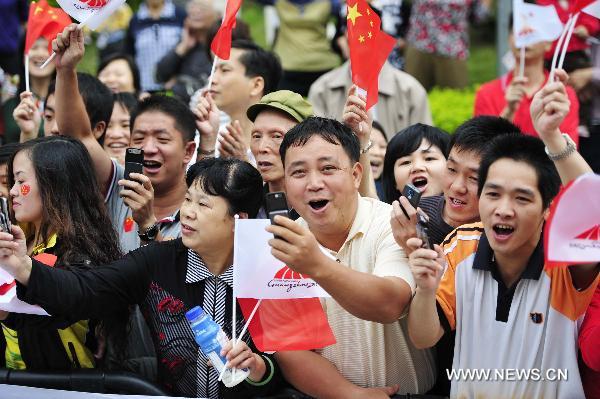 Local residents cheer for the torch relay for the 16th Asian Games in Heyuan City, south China's Guangdong Province, Oct. 25, 2010. (Xinhua/Liang Xu)