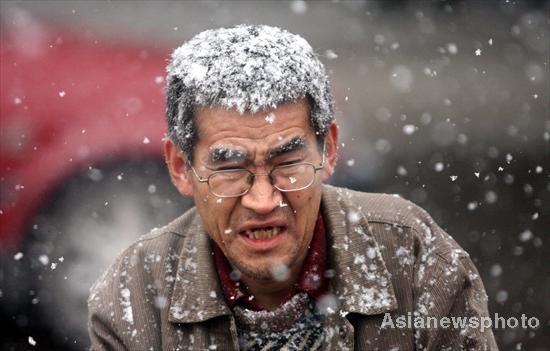 A man walks in the snow in Harbin, Northeast China&apos;s Heilongjiang province, Oct 25, 2010. The city witnessed the first snow shower of the season Monday, which resulted in a drop in temperature. 