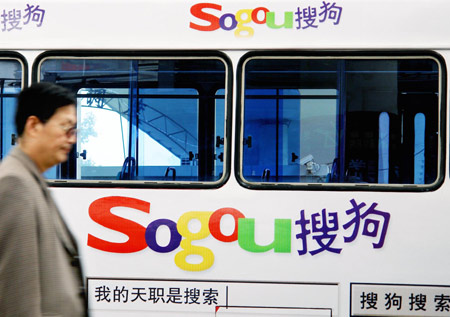 A man walks past a bus displaying an advertisement for major Chinese search engine Sogou.com in Zhengzhou, capital of Henan province. 