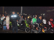 People try to reach their relatives by mobile phone as they flee to higher ground in Padang, West Sumatra, on October 25, 2010. [Xinhua] 