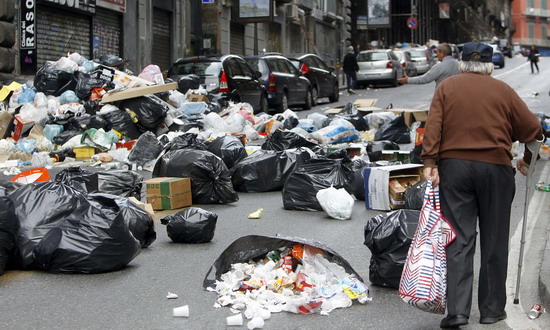 A man walks on a street full of rubbish in Naples Oct 24, 2010. The Italian government has put the opening of a new waste dump near Naples on hold after weeks of protests by residents, but demonstrators said the proposal was not enough and garbage continued to pile up in the streets.[China Daily/Agencies]