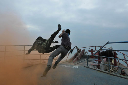 Police officers fight against a &apos;terrorist&apos; during an anti-terror and anti-smuggling drill at the Dapeng Bay off Shenzhen coast, South China&apos;s Guangdong province, Oct 25, 2010. [Xinhua]