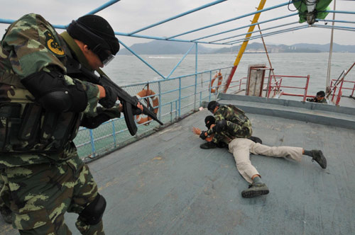 Police officers control a &apos;terrorist&apos; during an anti-terror and anti-smuggling drill at the Dapeng Bay off Shenzhen coast, South China&apos;s Guangdong province, Oct 25, 2010. [Xinhua]