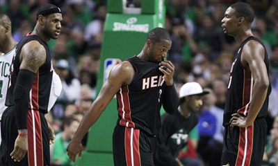 Miami Heat forward LeBron James talks with teammates Dwyane Wade and Chris Bosh while trailing the Boston Celtics during the first half of an NBA basketball game in Boston, Tuesday, Oct. 26, 2010. [SINA.com]