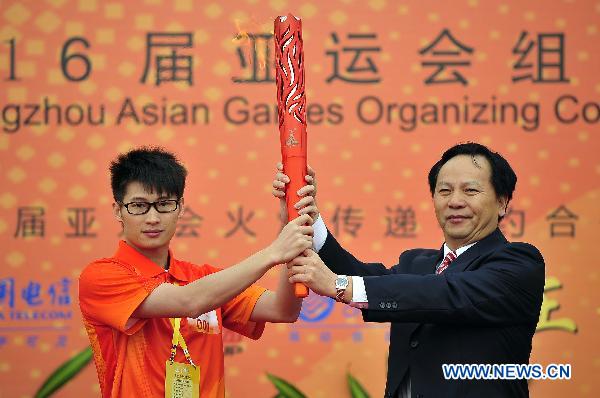 The first torchbearer Yang Jinghui (L) and Xu Jianhua, chairman of municipal committee of the Standing Committee of China's National People's Congress, also chief of municipal committee of the Communist Party of China, hold the torch aloft during the inauguration ceremony of the torch relay for the 16th Asian Games in Shaoguan City, south China's Guangdong Province, Oct. 27, 2010. (Xinhua/Liang Xu) 