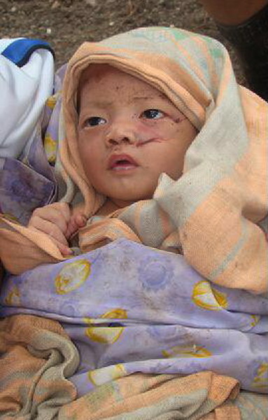 A villager holds a baby survivor, orphaned by the tsunami which hit Muntei Baru Baru village, in the Cikakap subdistrict of Indonesia&apos;s Mentawai islands October 26, 2010. [China Daily/Agencies]