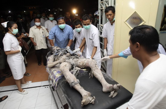 Paramedics wheel an Indonesian volunteer covered in ash on a stretcher at a hospital in Pakem district in Sleman, near Indonesia&apos;s ancient city of Yogyakarta October 26, 2010. The volcano Mount Merapi erupted on Tuesday, prompting terrified villagers to flee and join the thousands already evacuated from its slopes.[China Daily/Agencies]