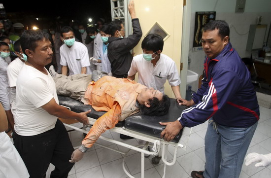 Paramedics wheel an Indonesian volunteer covered in ash on a stretcher at a hospital in Pakem district in Sleman, near Indonesia&apos;s ancient city of Yogyakarta October 26, 2010. The volcano Mount Merapi erupted on Tuesday, prompting terrified villagers to flee and join the thousands already evacuated from its slopes.[China Daily/Agencies]