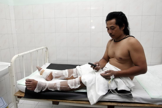 An Indonesian volunteer uses his mobile phone after being treated after Mount Merapi erupted, at a hospital in Pakem district in Sleman, near Indonesia&apos;s ancient city of Yogyakarta October 26, 2010. Mount Merapi erupted on Tuesday, prompting terrified villagers to flee and join the thousands already evacuated from its slopes.[China Daily/Agencies]