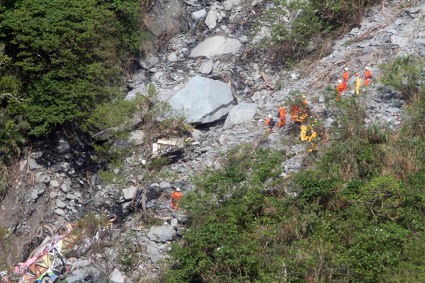 Rescuers search for survivors from a bus carrying tourists from the Chinese mainland hit by a landslide during Typhoon Megi, at the scene of the accident on Taiwan&apos;s Highway No 9 in north eastern Taiwan Oct 25, 2010. [Xinhua]