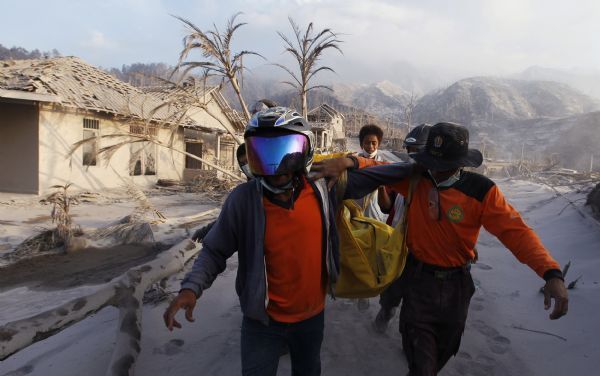 Volunteers carry the body of a victim of the Mount Merapi eruption at Kinarrejo village in Sleman, near the ancient city of Yogyakarta October 27, 2010. One of Indonesia's most active volcanoes spewed out clouds of ash and jets of searing gas on Wednesday in an eruption that has killed at least 29 people. [Xinhua]