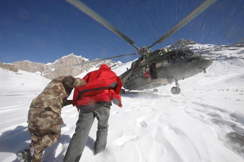 A rescuer and an engeer run for the helicopter during a rescue in Tianshan Mountains area near Baicheng county of Aksu prefecture in Northwest China's Xinjiang autonomous region, Oct 27, 2010. [Photo/Xinhua]