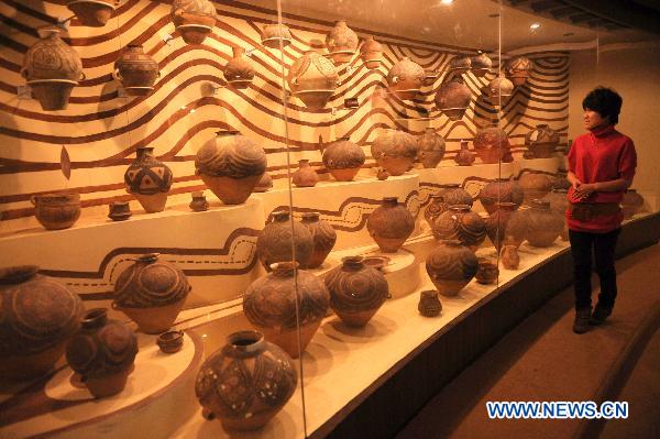 A woman looks at ancient painted potteries in the Liuwan Painted Pottery Museum at Liuwan Village of Ledu County, northwest China's Qinghai Province, Oct. 24, 2010. The museum houses some 40,000 ancient painted potteries, making it the largest of the kind in China. 