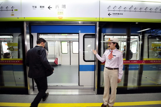 A train staffer guides passengers onto China&apos;s first intercity underground subway - the Guangzhou-Foshan Line - on Oct 28,2010. The Guangzhou-Foshan Line, which will open on Nov 3, runs through 14 stops: three stops in Guangzhou city and 11 stops in Foshan. Passengers from both cities can enjoy convenient one ticket-card service with no need to get out to transfer between stops.[Xinhua]