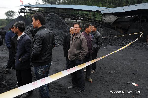  People stand outside the flooded Dapo coal mine in Machang Town of Puding County under Anshun City, southwest China&apos;s Guizhou Province, Oct. 28, 2010. The Dapo coal mine was flooded on Oct. 27, leaving 12 workers dead and another injured. [Xinhua] 