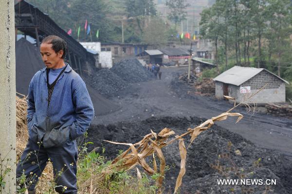 A worker stands outside the flooded Dapo coal mine in Machang Town of Puding County under Anshun City, southwest China&apos;s Guizhou Province, Oct. 28, 2010. The Dapo coal mine was flooded on Oct. 27, leaving 12 workers dead and another injured. [Xinhua]