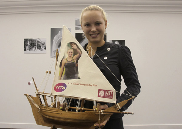 Caroline Wozniacki of Denmark holds small souvenir boats during their WTA Tour Championships tennis match in Doha October 28, 2010. (Xinhua/Reuters Photo)