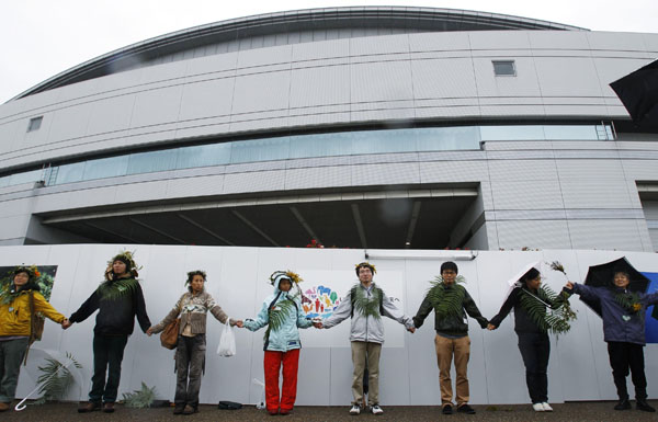 Participants hold hands as they attend a peaceful human chain event outside the venue of the 10th Conference of the Parties to the Convention on Biological Diversity (COP 10) in Nagoya, central Japan October 28, 2010. Participants formed a human chain in a bid to encourage a productive outcome from the U.N. meeting discussing ways to fight rising extinctions of plants and animals from pollution, climate change and habitat loss. 