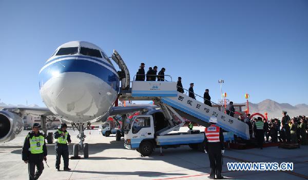 Three Tibetan women walks past a plane of Air China lands at Xigaze Airport in Xigaze, southwest China&apos;s Tibet Autonomous Region, on Oct. 30, 2010. Xigaze Airport opened Saturday, marking the launching of the fifth civil airport in Tibet.[Xinhua]